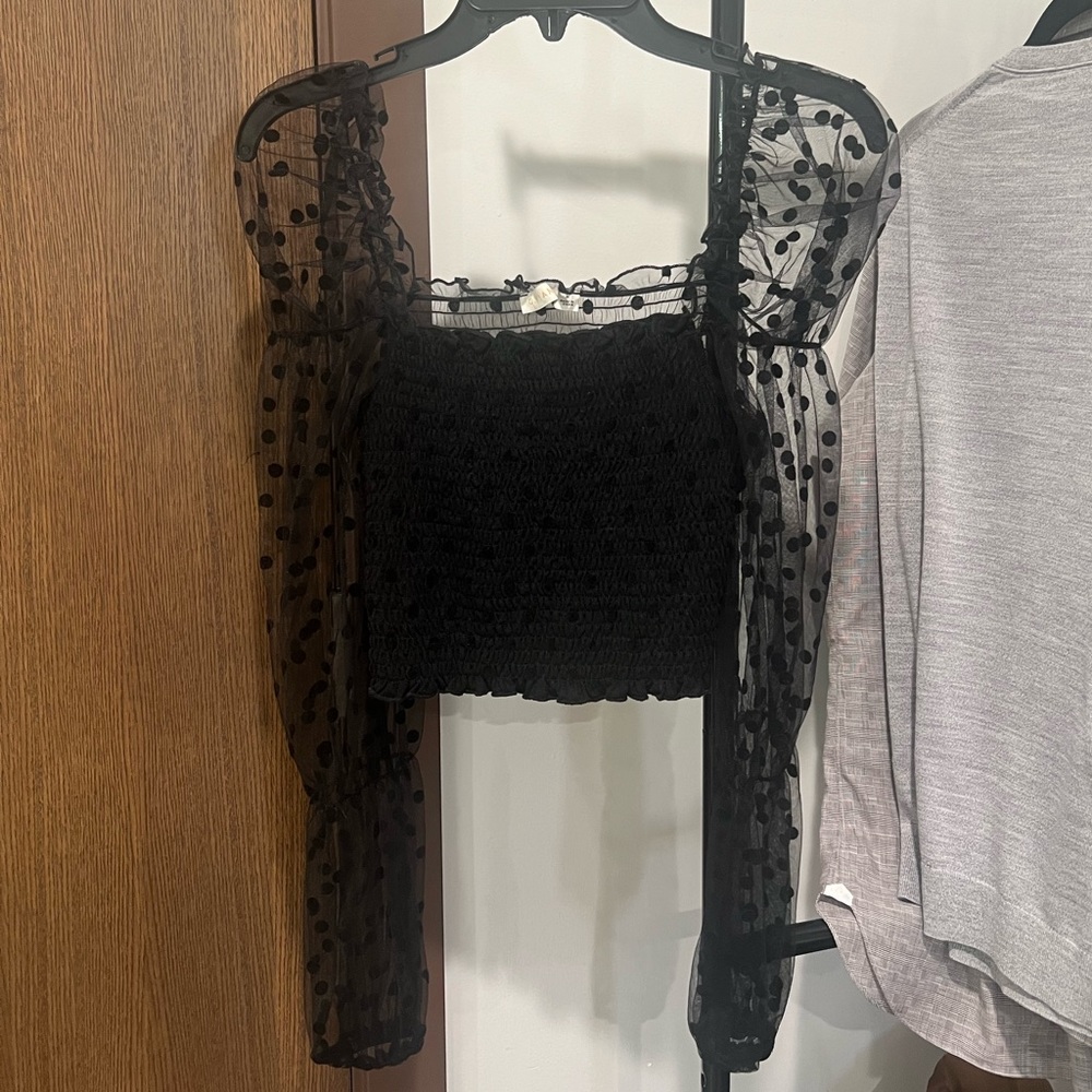 Black top with ruffles. See through back.